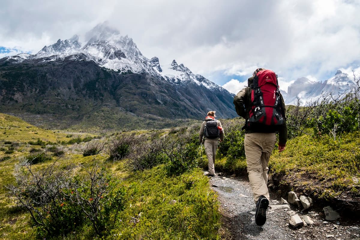 A hiker walking toward snowy peaks