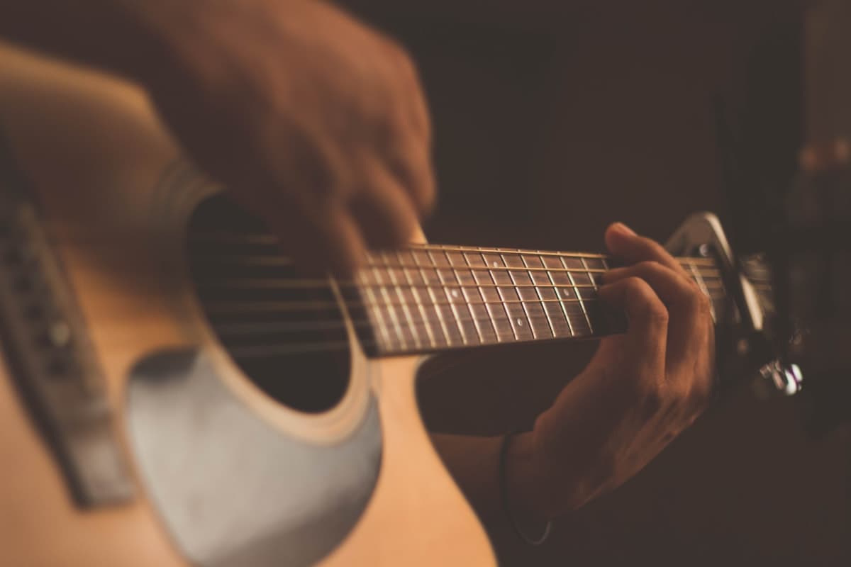 Hands playing an acoustic guitar