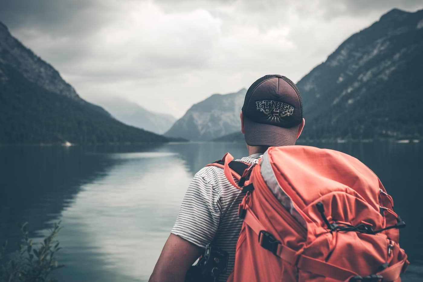 A traveler looking over mountains and a lake
